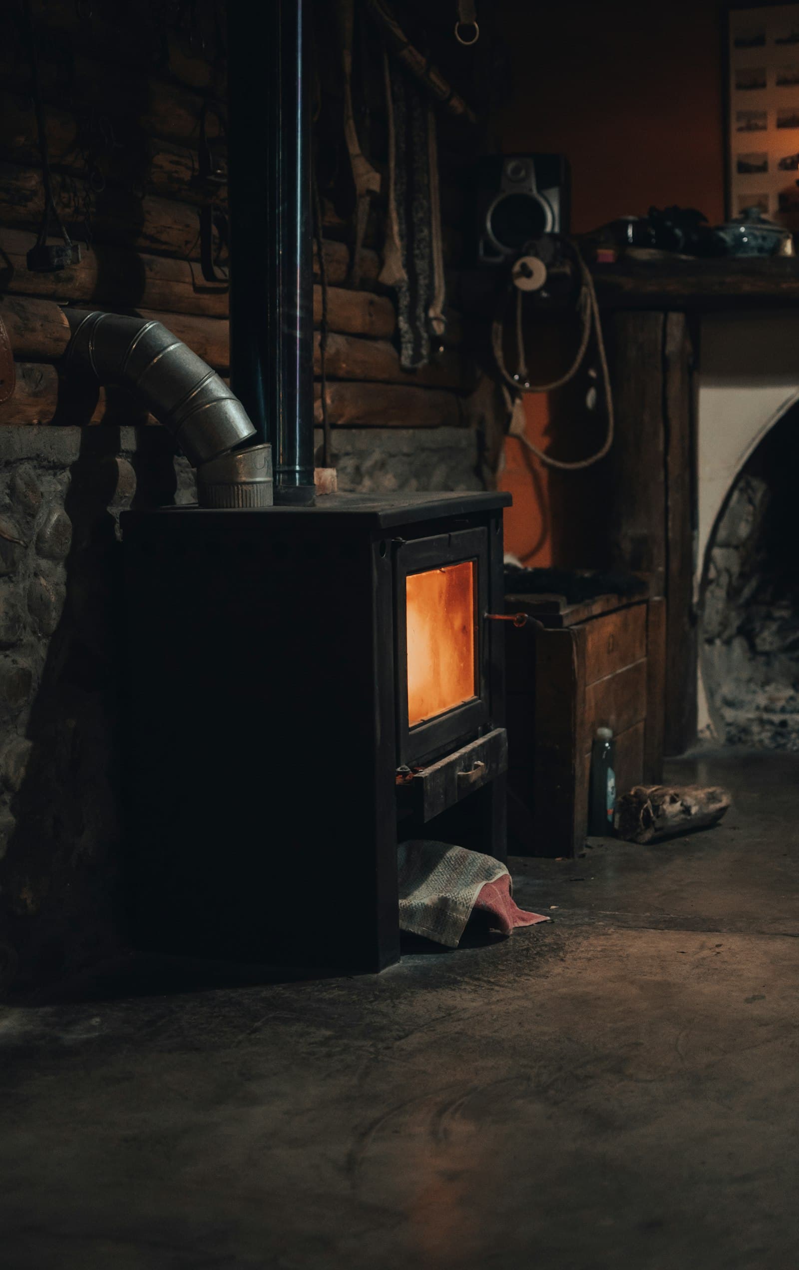 Poêle en fonte noir raccordé à un conduit de fumée dans une maison rénovée