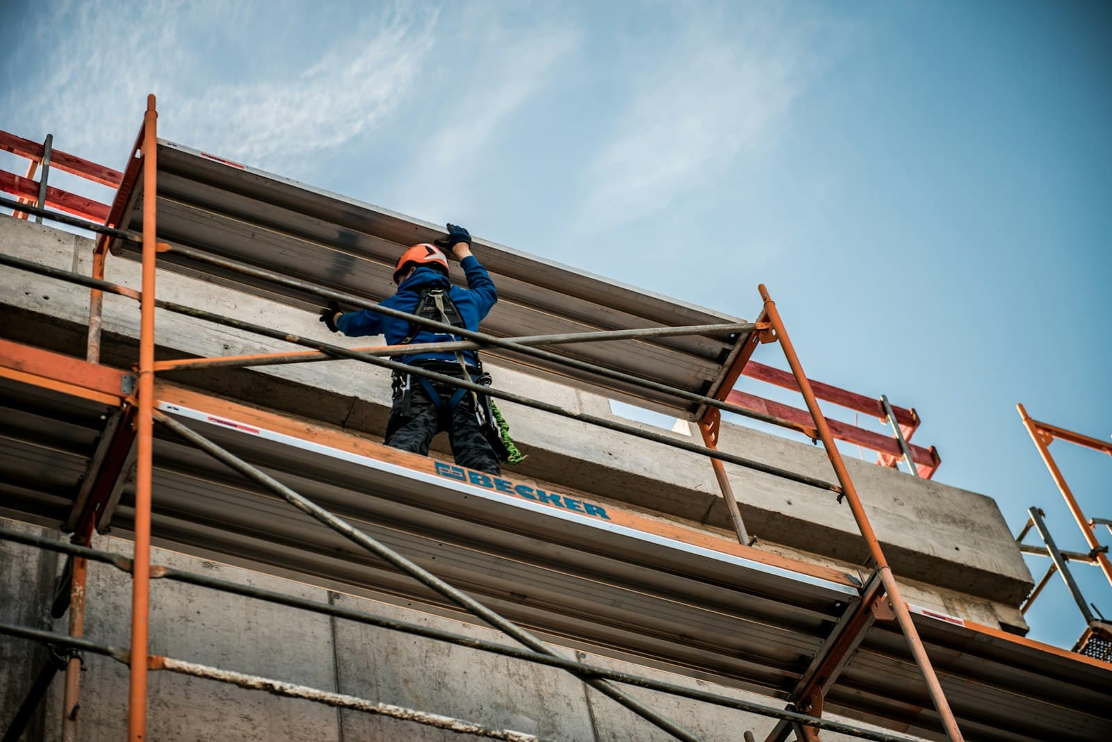 Ouvrier sur un échafaudage travaillant sur la façade d'un immeuble en rénovation