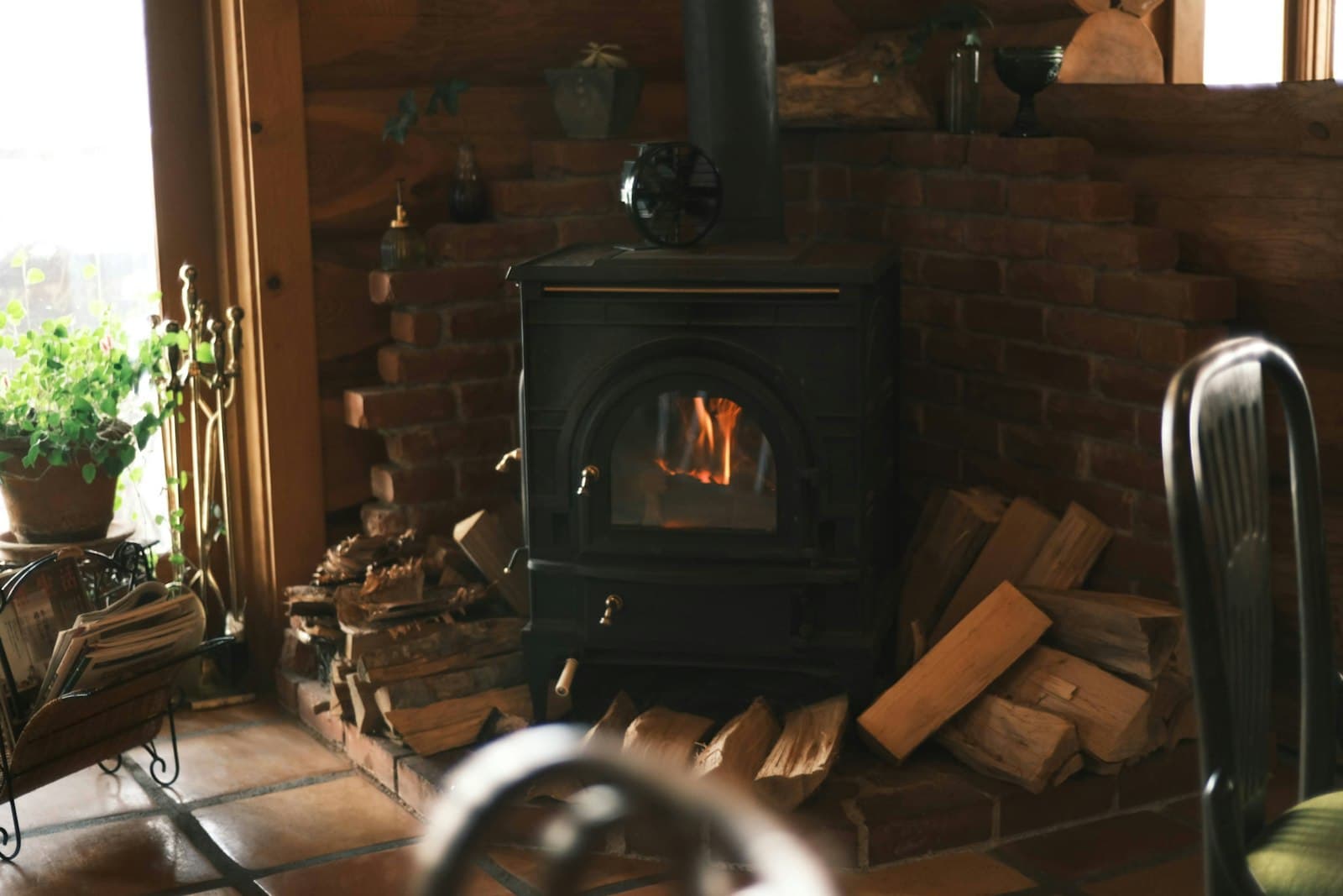 Poêle à bois moderne installé dans un séjour, flamme visible derrière la vitre
